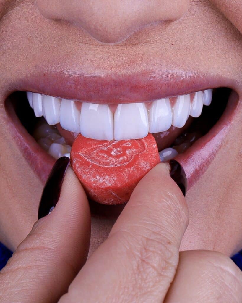 dentes com lentes de contato dental mordendo um chiclete